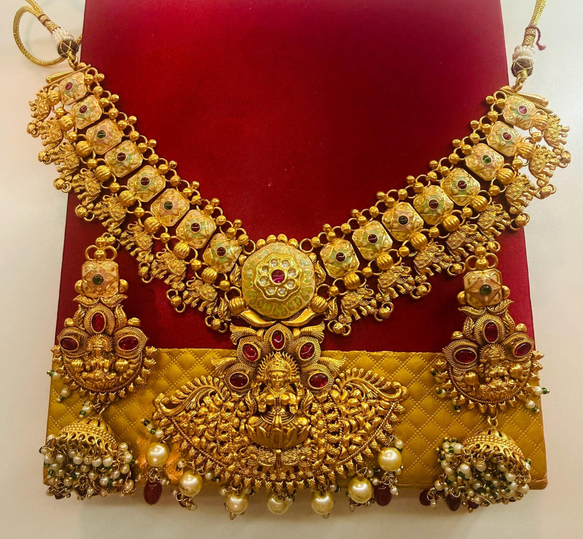 Gold-tone Lakshmi Kundan necklace and jhumka set – pearl-style and red bead detail